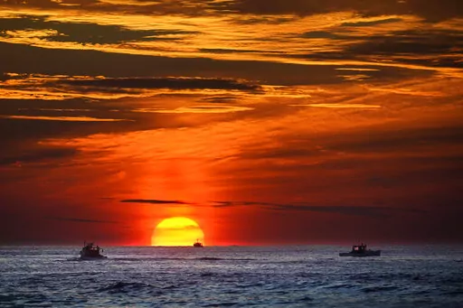Lobster fishermen are already at work as the sun rises over the Atlantic Ocean, Thursday, Sept. 8, 2022, off of Kennebunkport, Maine. (AP Phot6o/Robert F. Bukaty)