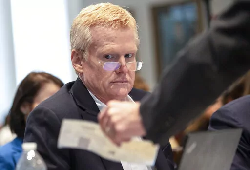 Alex Murdaugh looks over evidence of a check brought to him and his attorneys during his double murder trial at the Colleton County Courthouse on Tuesday, Feb. 7, 2023, in Walterboro, S.C. The 54-year-old attorney is standing trial on two counts of murder in the shootings of his wife and son at their Colleton County home and hunting lodge on June 7, 2021. (Andrew J. Whitaker/The Post And Courier via AP, Pool)/The Post And Courier via AP, Pool)