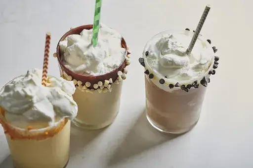 This 2019 image provided by Katie Workman shows leftover eggnog milkshakes, in vanilla, chocolate and mango variations in New York, N.Y. (Cheyenne M. Cohen via AP)