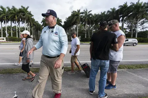 Alan Mentser, in foreground at left, from West Palm Beach, Fla., joins other supporters of President Donald Trump outside the Trump International Golf Club, Saturday, March 29, 2025, in West Palm Beach. (AP Photo/Manuel Balce Ceneta)