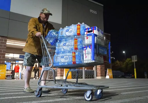 John Beezley, of Bonham, carts out several cases of water after learning that a boil water notice was issued for the entire city of Houston on Sunday, Nov. 27, 2022, at Walmart on S. Post Oak Road in Houston. Beezley just arrived in town with his wife, who is undergoing treatment starting tomorrow at M.D. Anderson Cancer Center, where they are staying in a camping trailer. They turned on the television after settling in and saw that a boil water notice had been issued. Beezley decided to go out 