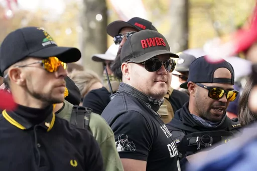 People identifying themselves as members of the Proud Boys join supporters of President Donald Trump for pro-Trump marches, Nov. 14, 2020, in Washington. Two supporter in the center are wearing hats with red lettering that read “RWDS,” which is short for “Right Wing Death Squad.” The gunman who killed eight people on Saturday, May 6, 2023, at a Dallas-area mall was wearing a “RWDS” patch. The phrase has been embraced in recent years by far-right extremists who glorify violence agains