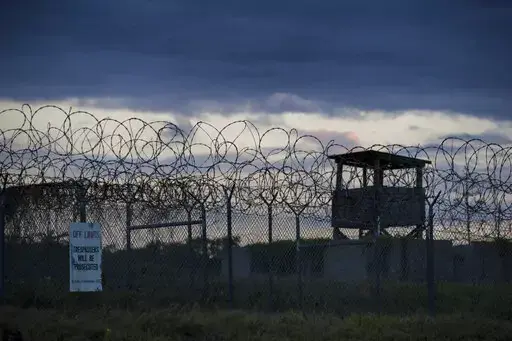 In this photo reviewed by U.S. military officials, the sun sets behind the closed Camp X-Ray detention facility, on April 17, 2019, in Guantanamo Bay Naval Base, Cuba. The Biden administration has been quietly laying the groundwork to release prisoners from the Guantanamo Bay detention center and at least move closer to being able to shut it down. (AP Photo/Alex Brandon, File)
