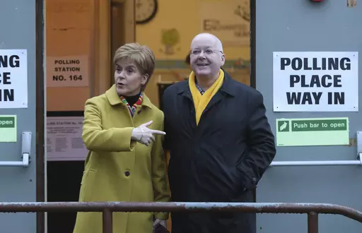 Scottish First Minister Nicola Sturgeon poses for the media with husband Peter Murrell, outside polling station in Glasgow, Scotland, on Dec. 12, 2019. British media are reporting that the husband of former Scottish National Party leader Nicola Sturgeon has been arrested in a party finance probe on Wednesday, April 5, 2023. (AP Photo/Scott Heppell, File)