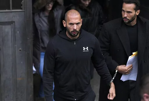 Andrew Tate, center, and his brother Tristan, leave after appearing at the Court of Appeal, in Bucharest, Romania, Tuesday, Jan.10, 2023. The divisive social media personality Andrew Tate arrived at a court in Romania in handcuffs on Tuesday morning to appeal a judge's earlier decision to extend his arrest period from 24 hours to 30 days on charges of being part of an organized crime group, human trafficking and rape. (AP Photo/Alexandru Dobre)