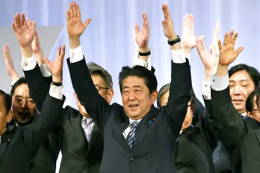 Japanese Prime Minister Shinzo Abe, center, shouts traditional "Banzai (long life)" cheers with lawmakers and members of his ruling Liberal Democratic (LDP) Party during its annual convention at a hotel in Tokyo on March 5, 2017. Assassinated former Prime Minister Shinzo Abe was perhaps the most divisive leader in recent Japanese history. He was also the longest serving and, by many estimations, the most influential. (AP Photo/Shizuo Kambayashi, File)