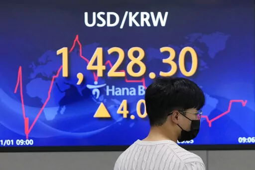 A currency trader walks by the screen showing the foreign exchange rate between U.S. dollar and South Korean won at a foreign exchange dealing room in Seoul, South Korea, Tuesday, Nov. 1, 2022. Shares have advanced in Asia despite a retreat on Wall Street. Hong Kong jumped more than 3% and most other indexes saw strong gains. (AP Photo/Lee Jin-man)