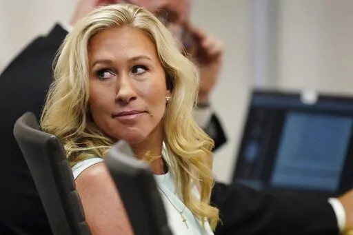 FILE-U.S. Rep. Marjorie Taylor Greene sits in a courtroom, Friday, April 22, 2022, in Atlanta. A judge in Georgia on Friday, May 6, found that Green can run for reelection, rejecting arguments from a group of voters who had challenged her eligibility over allegations that she engaged in insurrection. But the decision will ultimately be up to Republican Secretary of State Brad Raffensperger.(AP Photo/John Bazemore, Pool, File)