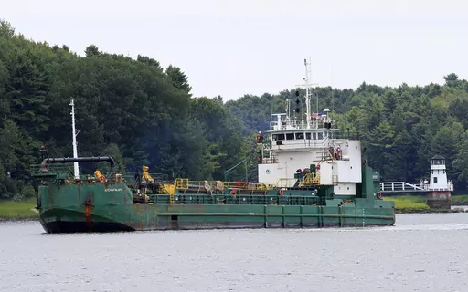Spectators watch as a dredger works to deepen a shallow channel in the Kennebec River, upstream from the Doubling Point Lighthouse, Aug. 5, 2011, in Arrowsic, Maine. Eleven people were hurt when a walkway collapsed during an annual event that encourages tours of Maine lighthouses. The wooden walkway collapsed at Doubling Point Lighthouse on Saturday, Sept. 9, 2023. (AP Photo/Robert F. Bukaty, file)