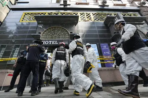 A joint investigation team arrives to examine the site of a hotel burnt by Thursday's fire in Bucheon, South Korea, Friday, Aug. 23, 2024. (AP Photo/Ahn Young-joon)