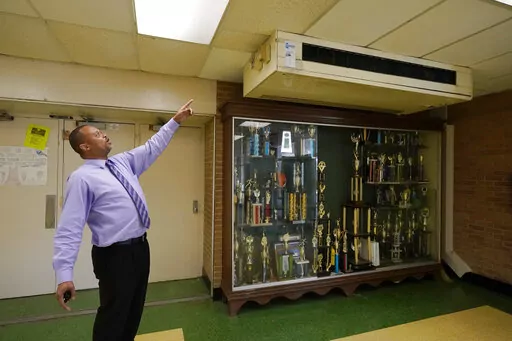 Jim Hill High School principal Bobby Brown, points out one of the outdated air-condition units that are installed throughout the Jackson, Miss., school, Jan. 12, 2023. A litany of infrastructure issues in the nearly 60-year-old school make for tough choices on spending COVID recovery funds on infrastructure or academics. (AP Photo/Rogelio V. Solis)