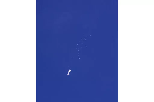 The remnants of a large balloon descend after it was struck by a missile from an F-22 fighter jet over the Atlantic Ocean, just off the coast of South Carolina near Myrtle Beach, Feb. 4, 2023. China's ceremonial parliament has accused American lawmakers of trampling on the sovereignty of other nations after the U.S. passed a measure condemning a suspected Chinese spy balloon's intrusion into U.S. airspace. (Chad Fish via AP, File)