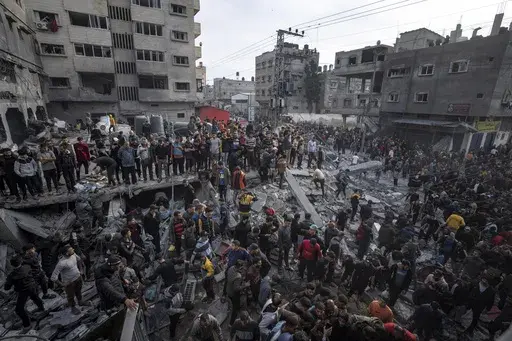 Palestinians search for bodies and survivors in the rubble of a residential building destroyed in an Israeli airstrike, in Rafah southern Gaza Strip, on Dec. 20, 2023. An AP analysis of Gaza Health Ministry data finds the proportion of Palestinian women and children being killed in the Israel-Hamas war appears to have declined sharply. Israel faces heavy international criticism over unprecedented levels of civilian casualties in Gaza. (AP Photo/Fatima Shbair)