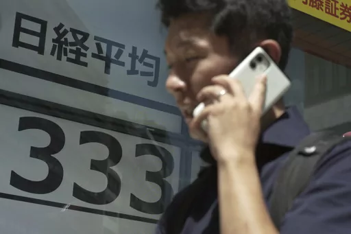 A man walks past monitors showing Japan's Nikkei 225 index at a securities firm in Tokyo, Monday, July 31, 2023. Shares were mostly higher in Asia on Monday after Wall Street got back to climbing following more encouraging profit reports and the latest signal that inflation is loosening its chokehold on the economy. (AP Photo/Hiro Komae)