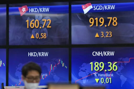 A currency trader stands near the screens showing the foreign exchange rates at a foreign exchange dealing room in Seoul, South Korea, Wednesday, May 25, 2022. Asian stock markets were mixed Wednesday after Wall Street sank on weak U.S. housing sales and a profit warning by a prominent social media brand. (AP Photo/Lee Jin-man)