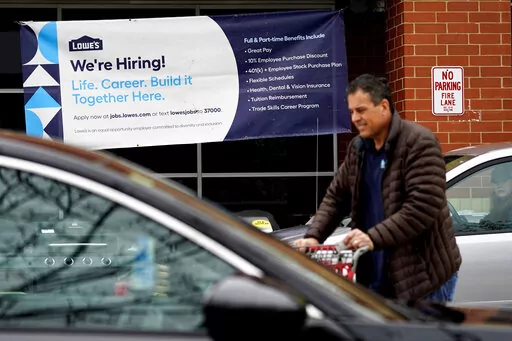 A hiring sign is displayed at a home improvement store in Northbrook, Ill., Thursday, May 5, 2022.  America’s employers added 428,000 jobs in April, extending a streak of solid hiring that has defied punishing inflation, chronic supply shortages, the Russian war against Ukraine and much higher borrowing costs.  (AP Photo/Nam Y. Huh)