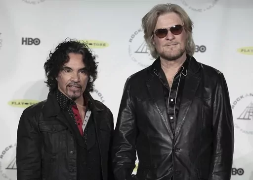 Hall of Fame Inductees John Oates, left, and Daryl Hall appear in the press room at the Rock and Roll Hall of Fame Induction Ceremony on April, 10, 2014, in New York. After more than a half-century of making music together, Hall is suing Oates over a proposed sale of his share of a Hall & Oates business partnership that Hall says he hasn't approved. A Nashville judge recently paused the sale of Oates' stake in Whole Oats Enterprises LLP to Primary Wave IP Investment Management LLC pending arbitr
