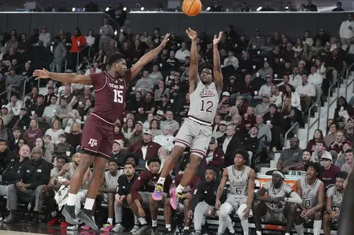 Mississippi State guard Josh Hubbard (12) shoots a three-point shot while Texas A&M forward Henry Coleman III (15) attempts to block during the second half of an NCAA college basketball game, Tuesday, Feb. 18, 2025, in Starkville, Miss. (AP Photo/Rogelio V. Solis)