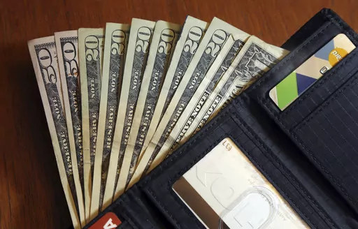 In this June 15, 2018, file photo, cash is fanned out from a wallet in North Andover, Mass. The holidays are a time when travel, gift buying and family outings are abundant. The season can lead you to feel pressured to spend more than you usually would. For this reason, it’s important to have financial boundaries in place to safeguard your finances. The steps that can help you establish and uphold financial boundaries include creating a financial plan for 2024, learning how to say no, acknowle