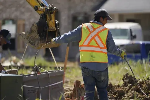 A worker lays a cable at a home building site in Flowood, Miss. on Sept. 23, 2021. (AP Photo/Rogelio V. Solis, File)
