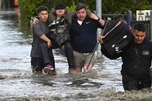 A woman is rescued from floodwater in Melbourne, Australia's suburb of Maribyrnong, Friday, Oct. 14, 2022. Rivers across Australia's most populous states, New South Wales and Victoria, and the island state of Tasmania were rising dangerously with catchments soaked by months of above-average rainfall. (Erik Anderson/AAP Image via AP)