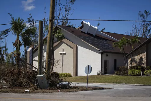 The steeple lays on its side atop Southwest Baptist Church in Fort Myers, Fla., on Sunday, Oct. 2, 2022. The church sustained heavy wind and flooding damage during Hurricane Ian as parishioners took refuge in the sanctuary. (AP Photo/Robert Bumsted)