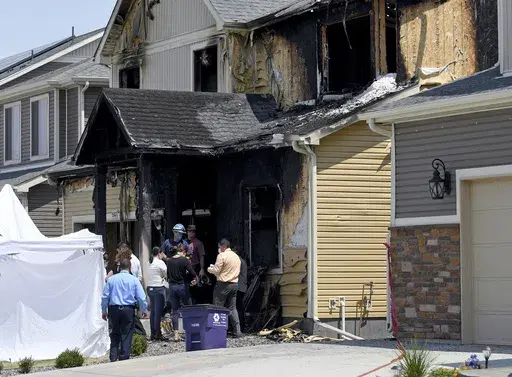 Investigators stand outside a house where five immigrants from Senegal were found dead after a fire in suburban Denver on Aug. 5, 2020. Kevin Bui pleaded guilty Friday, May 17, 2024, to a house fire that killed five members of the Senegalese family in 2020 in a case of misplaced revenge caused by mistakenly tracking his stolen iPhone to the home. (AP Photo/Thomas Peipert, File)