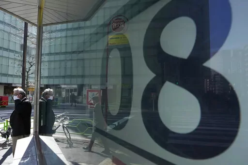 A man talks on the phone standing by monitors showing Japan's Nikkei 225 index at a securities firm in Tokyo, Wednesday, Feb. 9, 2022. Asian stocks rose Wednesday after Wall Street rebounded as investors waited for U.S. inflation data that might influence the pace of Federal Reserve interest rate hikes. (AP Photo/Hiro Komae)