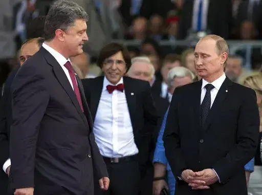 Ukrainian President Petro Poroshenko, left, walks past Russian President Vladimir Putin, right, during the commemoration of the 70th anniversary of the D-Day in Ouistreham, western France, June 6, 2014. The 2015 peace deal for eastern Ukraine was a diplomatic coup for Moscow, requiring Ukrainian authorities to offer self-rule to the Russia-backed separatist regions. (AP Photo/Alexander Zemlianichenko, file)