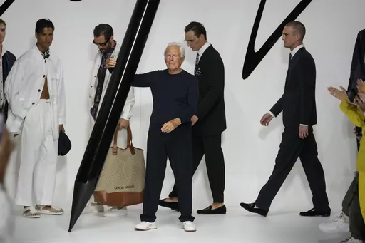 Designer Giorgio Armani receives applause at the end of the Giorgio Armani men's Spring Summer 2024 fashion show presented in Milan, Italy, Monday, June 19, 2023. (AP Photo/Luca Bruno)