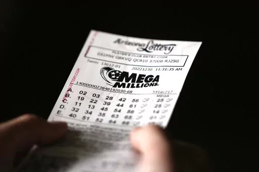 A person holds a Mega Millions lottery ticket in Tempe, Ariz., Friday, Dec. 30, 2022. The jackpot for the Friday drawing is estimated at $640 million. (AP Photo/Ross D. Franklin)