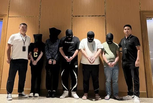 In this photo released by Xinhua News Agency, Myanmar police hand over five telecom and internet fraud suspects to Chinese police at Yangon International Airport in Yangon, Myanmar, Aug. 26, 2023. Tens of thousands of people, many of them Chinese, have been caught up in cyber scams based in Southeast Asia. Local and Chinese authorities have netted thousands of people in a crackdown on such schemes, but experts say they are failing to root out the local elites and criminal networks that are runni