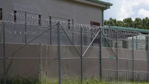 Rolls of razor wire line the top of the security fencing at the Raymond Detention Center in Raymond, Miss., on Aug. 1, 2022. Four prisoners are on the loose after escaping over the weekend from the Mississippi jail already under federal scrutiny for alleged mismanagement. In an escape that began around 8 p.m. Saturday, the four detainees broke free from the Raymond Detention Center, a facility near the state capital of Jackson, through breaches in a cell and in the roof, Hinds County Sheriff Tyr