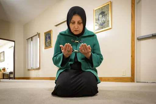 Bibi Bahrami prays at the Islamic Center of Muncie, Ind., on Friday, March 3, 2023, where she is one of the mosque's leaders. Bahrami is a subject of the documentary "Stranger at the Gate" that tells the story of the relationship she and others in their small Islamic community fostered with Richard McKinney, a former U.S. Marine who at one point had planned to bomb their community center. (AP Photo/Doug McSchooler)