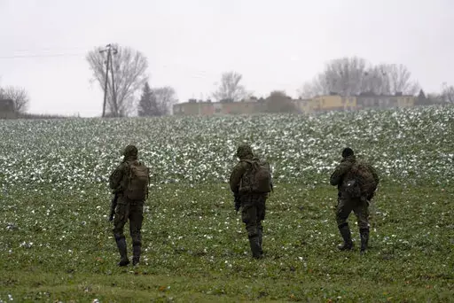 Polish soldiers search for missile wreckage in the field, near the place where a missile struck, in a farmland at the Polish village of Przewodow, near the border with Ukraine, Thursday, Nov. 17, 2022. (AP Photo/Vasilisa Stepanenko)