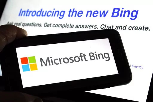 The Microsoft Bing logo and the website's page are shown in this photo taken in New York on Tuesday, Feb. 7, 2023. Microsoft is ready to take its new Bing chatbot mainstream — less than a week after making major fixes to stop the artificially intelligent search engine from going off the rails. The company said Wednesday, Feb. 22, it is bringing the new AI technology to its Bing smartphone app, as well as the app for its Edge internet browser. (AP Photo/Richard Drew)