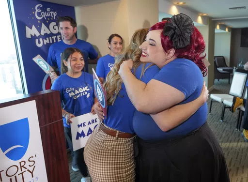 Disneyland Resort Cast Members, Courtney Griffith, left, hugs Angela Nichols after a news conference in Anaheim, Calif., Wednesday, April 17, 2024. Workers who help bring Disneyland's beloved characters to life said Wednesday they collected enough signatures to support their push for a union. (AP Photo/Damian Dovarganes)