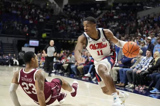 Mississippi guard Matthew Murrell (11) dribbles past falling Troy guard Aamer Muhammad (23) during the first half of an NCAA college basketball game Tuesday, Dec. 19, 2023, in Oxford, Miss. (AP Photo/Rogelio V. Solis)