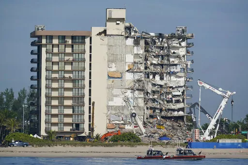 Coast Guard boats patrol in front of the partially collapsed Champlain Towers South condo building, July 1, 2021, in Surfside, Fla. A nearly $1 billion tentative settlement has been reached in a class-action lawsuit brought by families of victims and survivors of last June's condominium collapse in Surfside, Fla., an attorney said Wednesday, May 11, 2022. (AP Photo/Mark Humphrey, File)