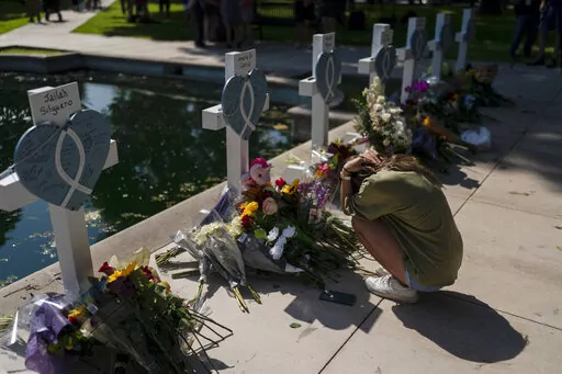 Elena Mendoza, 18, grieves in front of a cross honoring her cousin, Amerie Jo Garza, one of the victims killed in this week's elementary school shooting in Uvalde, Texas, Thursday, May 26, 2022. (AP Photo/Jae C. Hong)