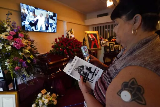 Donna Hoffmann, third cousin to rock and roll pioneer Jerry Lee Lewis, views his casket before his funeral service in Ferriday, La., Saturday, Nov. 5, 2022. (AP Photo/Gerald Herbert)