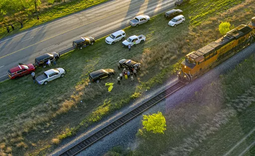 Officials investigate the scene where migrants were found trapped in a train car, Friday, March 24, 2023 in Ulvalde, Texas. Union Pacific railroad said in a statement that the people were found in two cars on the train traveling east from Eagle Pass bound for San Antonio. (William Luther/The San Antonio Express-News via AP)