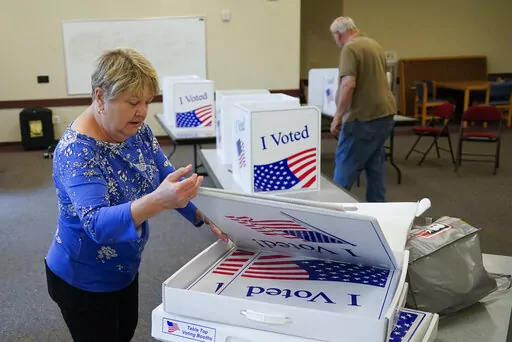 Cecelia Peterson, the majority inspector for the Cranberry West 5 voting precinct, left, and clerk Fred Peterson set up some of the folding voting booth dividers in one of the rooms in the Cranberry Township Municipal Center that will be used for voting in Tuesday's Pennsylvania Primary Election, Monday, May 16, 2022, in Cranberry Township, Butler County, Pa. (AP Photo/Keith Srakocic)