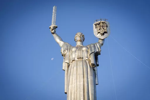 Workers install the Ukrainian coat of arms on the shield in the hand of the country's tallest stature, the Motherland Monument, after the Soviet coat of arms was removed, in Kyiv, Ukraine, Sunday, Aug. 6, 2023. Ukraine is accelerating efforts to erase the vestiges of centuries of Soviet and Russian influence from the public space amid the Russian invasion of Ukraine by pulling down monuments and renaming hundreds of streets to honor home-grown artists, poets, military chiefs, and independence le