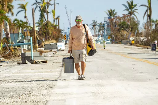 Gerry Arnold leaves Pine Island, Fla., after gathering a few belongings from his home after Hurricane Ian left behind widespread damage across the city on Tuesday, Oct. 4, 2022. (Scott Clause/The News-Press via AP)