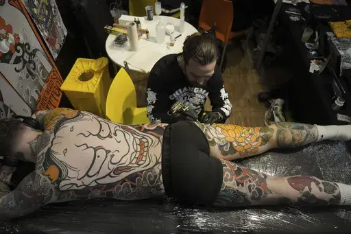 A man gets a tattoo done during a Tattoo Convention, in Paris, Saturday, Feb. 1, 2025. (AP Photo/Thibault Camus)