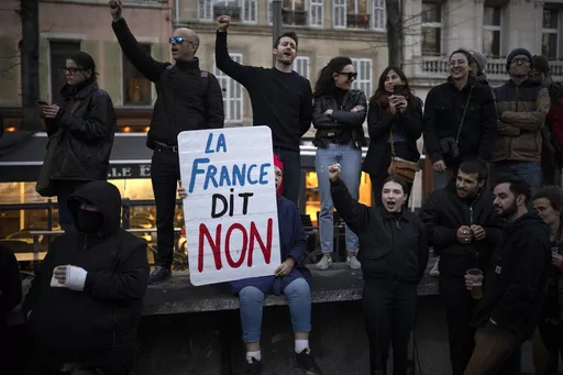 A woman holds a sign reading "France says no" during a demonstration in Marseille, southern France, Thursday, March 16, 2023. With President Emmanuel Macron thousands of miles away in China, French protesters and unions returning to the streets continue to reveal cracks in his domestic political authority. Hundreds of thousands are expected again for the 11th day of nationwide resistance to raising the retirement age from 62 to 64 Thursday, April 6 as the controversial law is being considered by