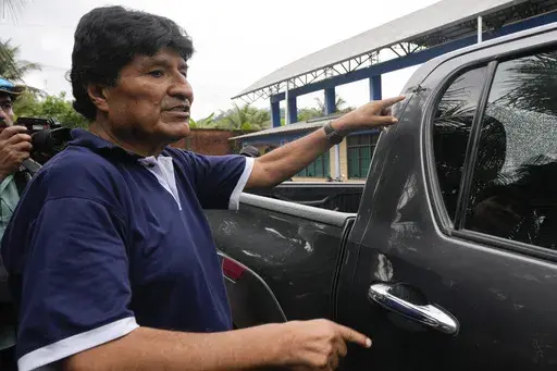 Former Bolivia's President Evo Morales points to a bullet hole on his car that he claims was the result of an assassination attempt, in Lauca N, Chapare region, Bolivia, Nov. 3, 2024, amid an ongoing political conflict with the government of President Luis Arce. (AP Photo/Juan Karita, File)