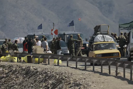Ethnic Armenians from Nagorno-Karabakh and European Union observers drive their cars past a check point on the road from Nagorno-Karabakh to Armenia's Goris in Syunik region, Armenia, Friday, Sept. 29, 2023. Armenian officials say more than 70% of Nagorno-Karabakh's original population have fled the region for Armenia. (AP Photo/Vasily Krestyaninov)