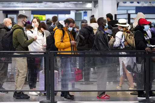 Travelers line up for flights at O'Hare International Airport in Chicago, Thursday, Dec. 30, 2021. (AP Photo/Nam Y. Huh)
